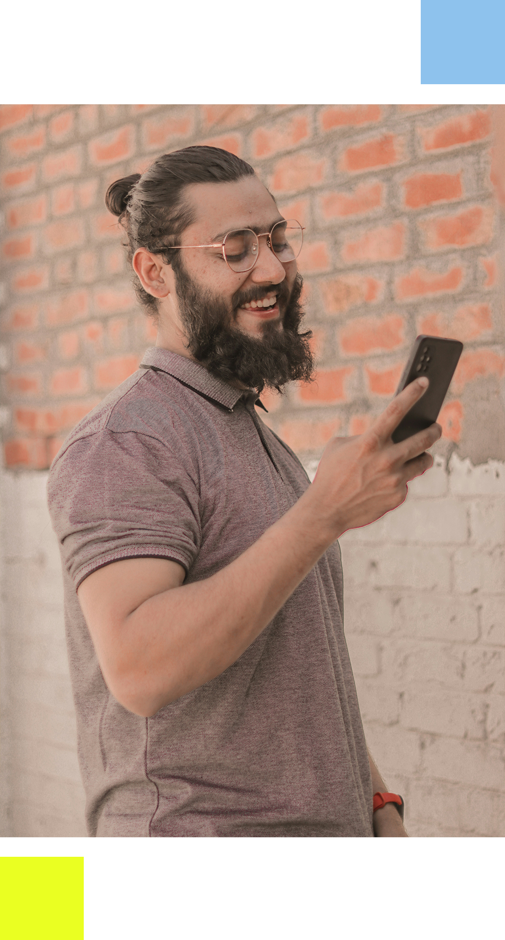 man smiling while looking at his iphone.